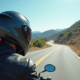 Motocycliste casque intégral en mouvement sur route panoramique