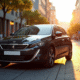 Peugeot 308 moderne stationnée en ville lors de l'heure dorée